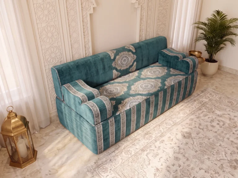 High-angle view of a teal velvet majlis sofa with ivory medallions woven across the seat top