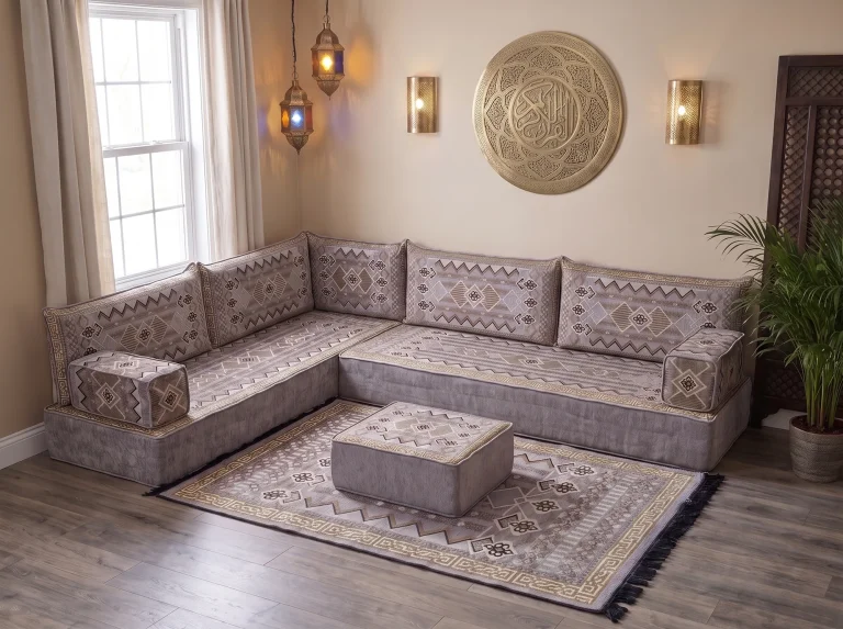 Thick gray and gold kilim-pattern floor sofa set in an L shape with matching rug and ottoman below a brass wall plate