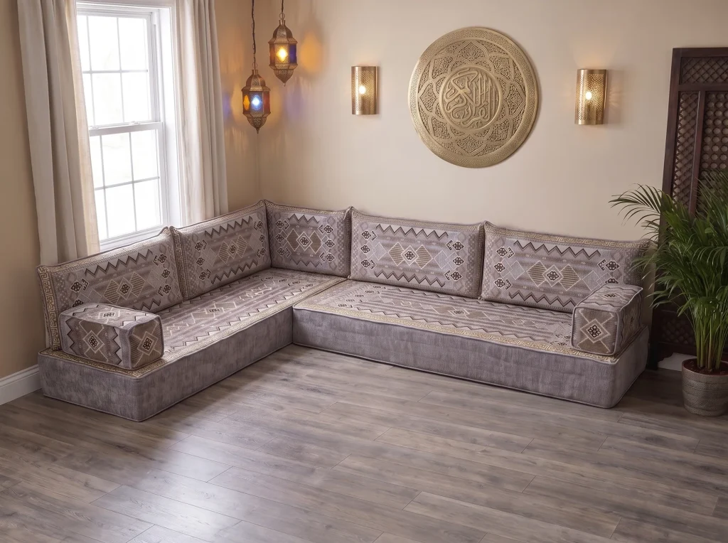 Thick gray and gold kilim-pattern floor sofa set in an L shape on a bare wood floor under a brass calligraphy wall plate