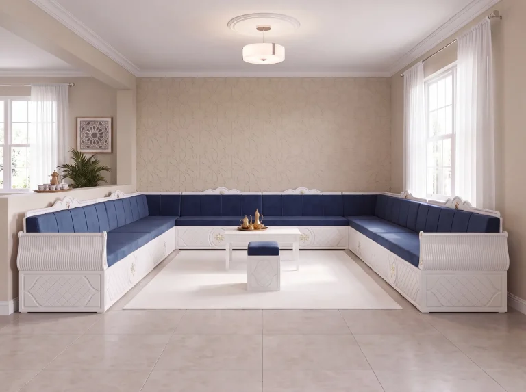 White-framed majlis sofa set in a U shape with navy cushions around one long coffee table and an ottoman